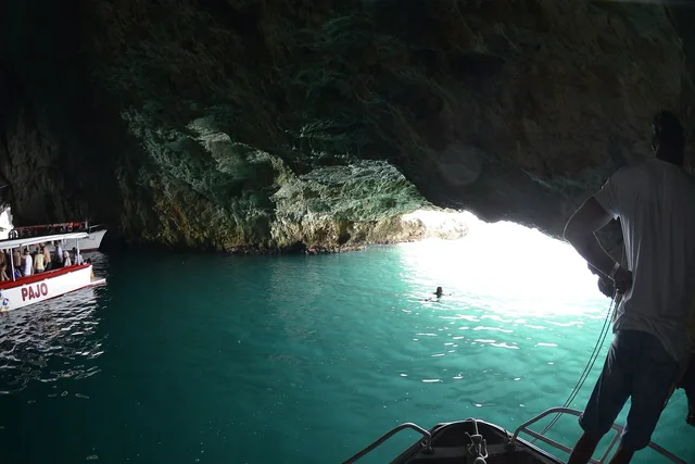 Tour boats entering the turquoise waters of the Blue Cave in Montenegro